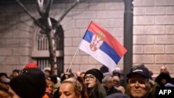 Devojka drži zastavu Srbije na protestnom skupu ispred Republičke izborne komisije (RIK) u Beogradu (Foto: OLIVER BUNIC / AFP)) 
