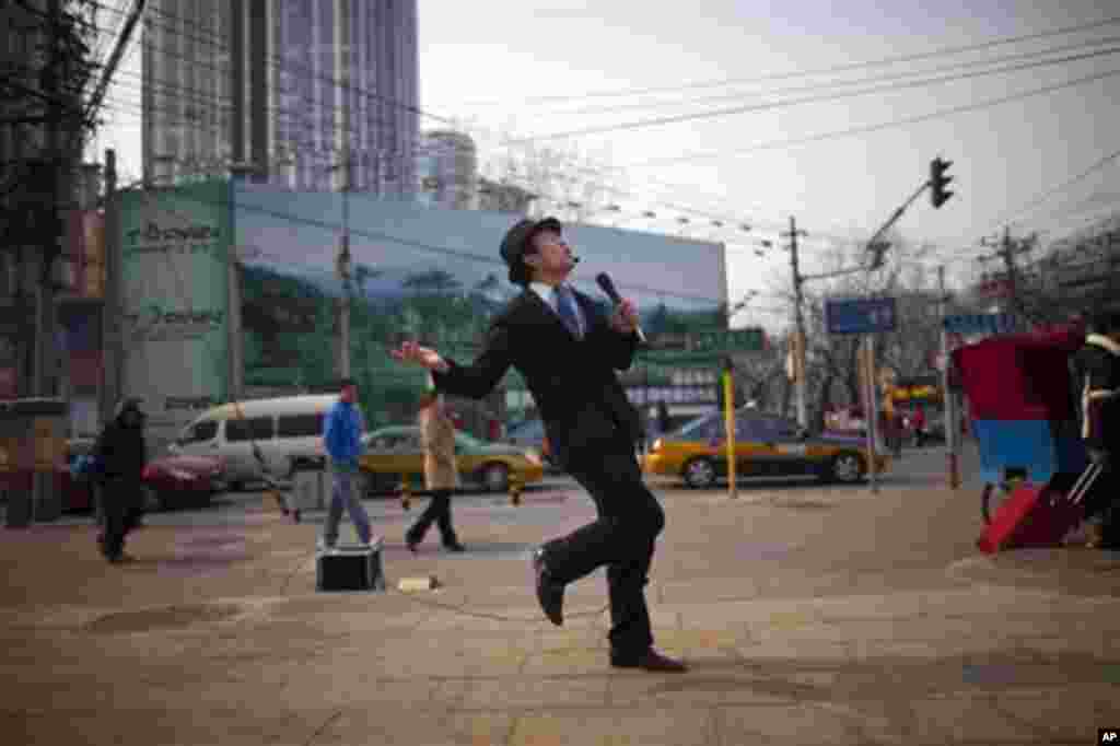 A man dances as he sings karaoke on a street in central Beijing, China, Tuesday, Feb. 21, 2012.