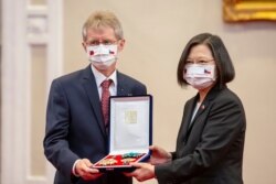 In this photo released by the Taiwan Presidential Office, the Czech Senate President Milos Vystrcil is presented a medal by Taiwanese President Tsai Ing-wen during a meeting in Taipei, Taiwan, Sept. 3, 2020.