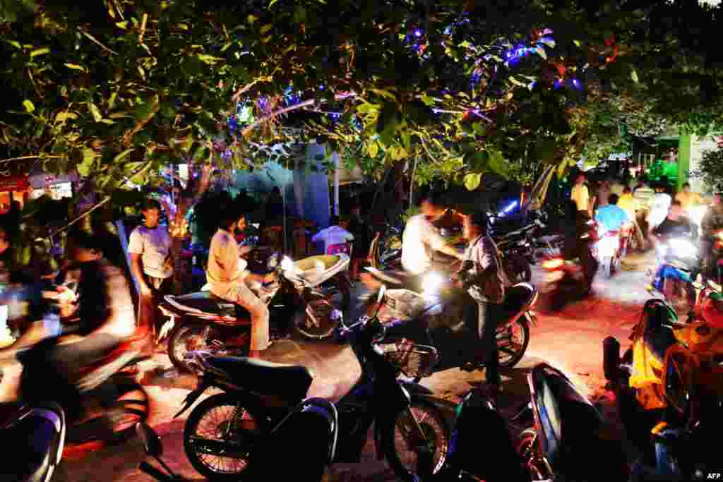 Residents of Male, the capital of Maldives, use mopeds to drive past a popular night spot of the city, Sept. 4, 2013. Mopeds are the most popular mode of transportation in the streets of this very small, crowded city.