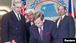 FILE - Czech President Vaclav Havel (C) signs a memory book at the entrance of the Radio Free Europe/Radio Liberty headquarters in Prague, May 4, 2001.