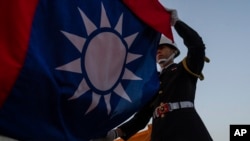 FILE - An honor guard takes part in a flag-lowering ceremony at Chiang Kai Shek Memorial Hall in Taipei, Taiwan, on Jan. 12, 2024. The Taiwan High Court on Aug. 23, 2024, sentenced eight military officers to prison for spying.