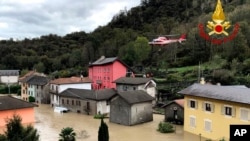 A firefighters' helicopter flies over flooding in the town of Ornavasso, in the northern Italian region of Piedmont, Oct. 4, 2020.