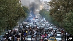 Manifestantes protestan en las calles de Teherán, el 21 de septiembre de 2022. [Foto tomada por una persona en Irán y divulgada por AP].