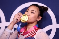 Gold medalist Sunisa Lee of the United States kisses her medal in front of the olympic rings, Ariake Gymnastics Centre, Tokyo, Japan - July 29, 2021.