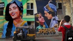 Seorang turis memotret mural yang menggambarkan film India "Anarkali" di Mumbai, India, 21 April 2013 (Foto: dok).