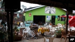 FILE - Damaged chairs and tables lie among the debris strewn after a bomb attack outside an Ethiopian restaurant in Kampala, July 12, 2010.