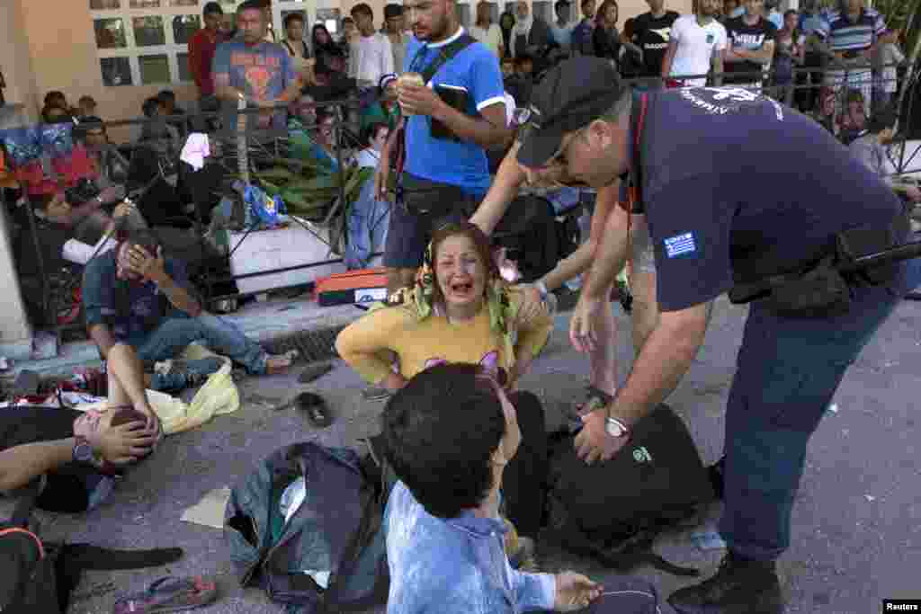 Seorang pengungsi Afghanistan menangis setelah jatuh dalam bentrokan antara polisi Yunani dan para pengungsi yang memprotes prioritas prosedur registrasi di pelabuhan Mytilene di pulau Lesbos, Yunani (5/9). ​(Reuters/Dimitris Michalakis)