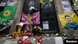 Flags, flowers and candles displayed by members of the Kurdish community are seen in front of the entrance of the Information Centre of Kurdistan where three Kurdish women were found shot dead, in Paris, January 11, 2013.