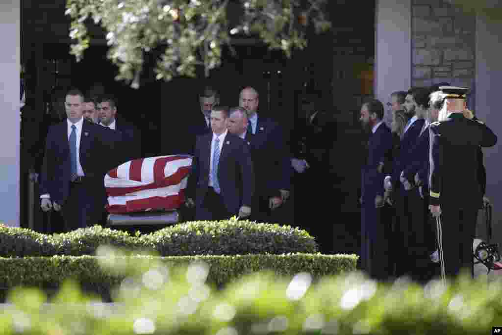 Kikosi maalum cha kumlinda Rais wa Marekani wakiwa wamebeba jeneza la Rais mstaafu George H.W Bush katika nyumba ya kutayarisha maiti baada ya familia kufanya maombi, Jumatatu, Desemba 3, 2018, huko Houston. Jumatatu, Desemba 3, 2018, huko mjini Houston. (AP Photo/Kiichiro Sato)