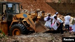 Deprem şiddetli yağmurun ulaşımı zorlaştırdığı deprem bölgesinde ilaç boşaltan bir traktör