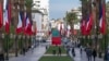 People walk past Moroccan and French flags on Mohammed V avenue ahead of French president Emmanuel Macron official visit to Morocco, in the capital Rabat, Oct. 28, 2024. 