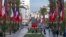 People walk past Moroccan and French flags on Mohammed V avenue ahead of French president Emmanuel Macron official visit to Morocco, in the capital Rabat, Oct. 28, 2024. 