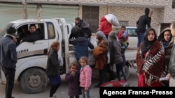 Syrians flee their homes in the Ghwayran neighborhood in the northern city of Hasakeh on Jan. 23, 2022, on the fourth day of fighting between the Kurdish forces and Islamic State (IS) group fighters.