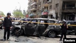Policemen secure the site of a car bomb attack on the convoy of Egyptian public prosecutor Hisham Barakat near his house at Heliopolis district in Cairo, June 29, 2015. 