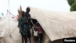 FILE - A woman from the Murle tribe and her children stand outside their tent in Pibor town in Jonglei State, South Sudan, July 18, 2013.