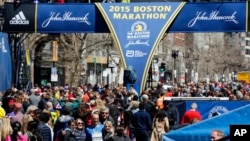 Runners and spectators crowd the finish line on Boyston Street, a day ahead of the 119th Boston Marathon in Boston, Massachusetts, April 19, 2015.