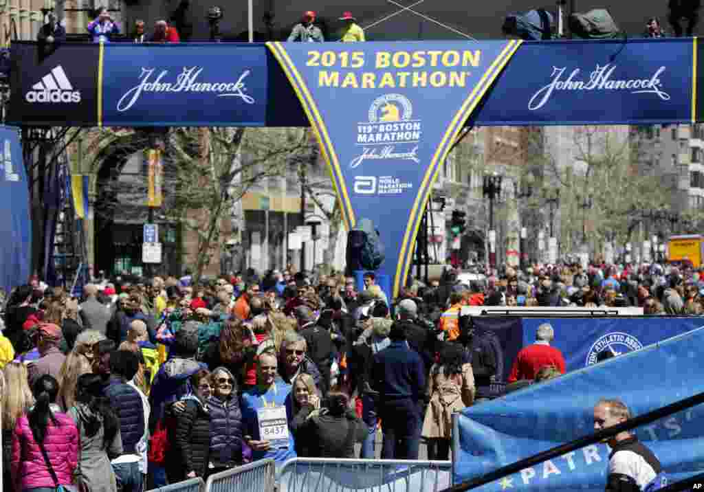 Runners and spectators crowd the finish line on Boyston Street, a day ahead of the 119th Boston Marathon in Boston, MA, April 19, 2015.