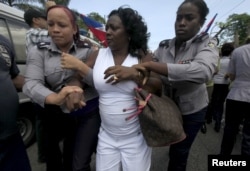 FILE - Berta Soler, leader of The Ladies in White, an opposition group, is detained by Cuban security personnel after a weekly anti-government protest march, in Havana, Sept. 13, 2015.