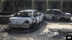 Rongsokan kendaraan yang terbakar terlihat di wilayah pusat bisnis di kota Potiskum, Nigeria (Foto: dok). Seorang kepala kepolisian dan 14 orang tersangka anggota Boko Haram dikabarkan tewas dalam aksi penembakan di wilayah ini, Selasa (11/12).