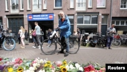 FILE PHOTO: A man looks on next to a makeshift altar at the place where Dutch celebrity crime reporter Peter R. de Vries was fatally shot in Amsterdam, Netherlands, July 7, 2021.