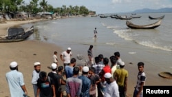 Warga setempat berkumpul di sekitar mayat anak-anak pengungsi Rohingya dari Myanmar yang tewas saat kapal mereka terbalik dalam perjalanan ke Bangladesh, di Shah Porir Dwip, Teknaf, dekat Cox's Bazar, Bangladesh, 9 Oktober 2017.