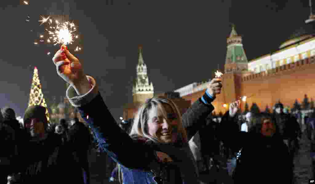 Russians celebrate the New Year on Red Square in Moscow, with the Kremlin in the background, right, and St. Basil's cathedral in background left, , Sunday, Jan. 1, 2012. (AP)
