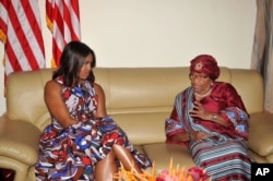 FILE - Then-U.S. First lady Michelle Obama, left, listens to Liberian President Ellen Johnson Sirleaf, right, after she arrived at the airport in Monrovia, Liberia, June 27, 2016.