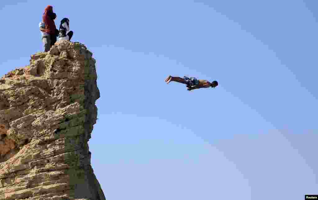 A man jumps into the water, above Cleopatra's Beach, on a summer’s day at the Mediterranean city of Marsa Matrouh, northwest of Cairo, Egypt, June 16, 2015.