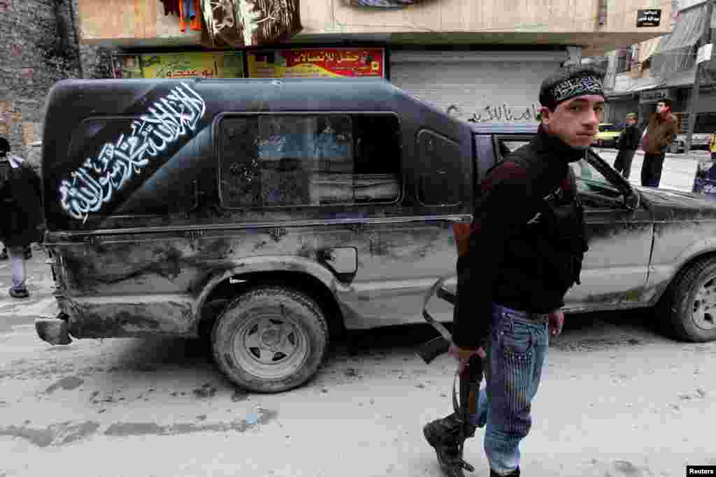 A member of the Free Syrian Army holds a weapon as he walks in Aleppo, Syria, December 28, 2012.