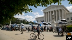 Members of the media set up outside the Supreme Court, Thursday, July 9, 2020, in Washington. The Supreme Court ruled Thursday that the Manhattan district attorney can obtain Trump tax returns while not allowing Congress to get Trump tax and financial rec