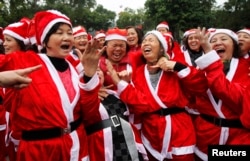 Members of the Laughter Yoga club in Santa Claus costumes practise laughing exercises at a public park in Hanoi, Vietnam, December 23, 2012.