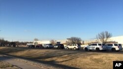 In this photo provided by KWCH-TV, police vehicles line the road after reports of a shooting at an industrial site in Hesston, Kan., Feb. 25, 2016. 