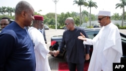 President of Nigeria Muhammadu Buhari (R) greets former President of Ghana John Mahama (2nd R) in Abuja on Jan. 9, 2017.