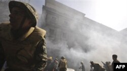 Пожарные на месте происшествия. Бывшие сотрудники полиции в знак протеста подожгли часть Министерства внутренних дел в Каире. Египет. 23 февраяля 2011 года