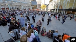 People wait outside the Cologne train station on Oct. 15, 2018. Cologne police closed parts of the western German city’s main train station after a man took a woman hostage in a pharmacy inside.