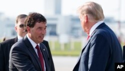 Le président Donald Trump est accueilli par le candidat républicain, Troy Balderson, à son arrivée sur l’Air Force One à l’aéroport international John Glenn Columbus de Columbus, Ohio, le 4 août 2018.