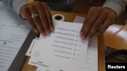 Un ciudadano sostiene una papeleta durante las elecciones presidenciales en un colegio electoral en Santiago, Chile, 21 de noviembre de 2021