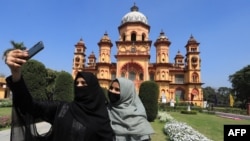 FILE —In this picture taken on March 13, 2024, Muslim girls take their selfie in front of Raza Library at Rampur in India's Uttar Pradesh state.