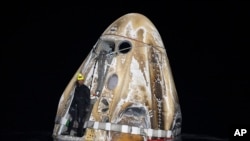 Esta fotografía proporcionada por la NASA muestra a un miembro del equipo de apoyo trabajando en la nave espacial Dragon Endeavour de SpaceX poco después del acuatizaje, en el Golfo de México frente a la costa de Pensacola, Florida, el viernes 25 de octubre de 2024. 