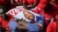 FILE - An opposition party supporter covers his face with a campaign poster of Nelson Chamisa in Harare, July 28, 2018.