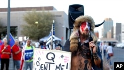 FILE - Jacob Anthony Chansley, who also goes by the name Jake Angeli, a QAnon follower, speaks to supporters of then-President Donald Trump outside of the Maricopa County Recorder's Office, in Phoenix, Nov. 5, 2020.