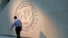 FILE — A man walks past the International Monetary Fund (IMF) logo at its headquarters in Washington, U.S., May 10, 2018. 