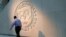 FILE — A man walks past the International Monetary Fund (IMF) logo at its headquarters in Washington, U.S., May 10, 2018. 