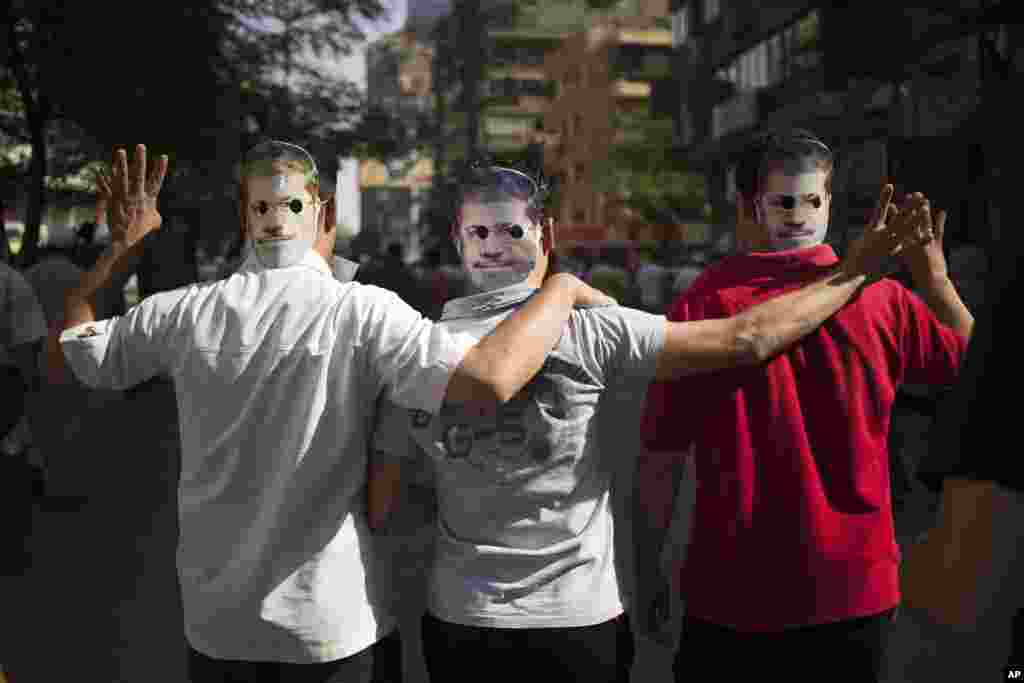 Supporters of Egypt's ousted President Mohamed Morsi wear masks with the former leader's likeness during a protest in Cairo, Oct. 4, 2013.