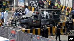 Pakistani security personnel surround a damaged police van in Lahore, Pakistan, Wednesday, May 8, 2019.