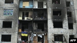 Local residents clear debris from their apartments at a heavily damaged residential building, three days after a Russian missile attack in Kyiv, Jan. 5, 2024.