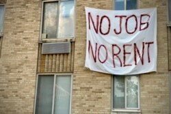 FILE - A banner against renters' evictions reading “No job, no rent” is seen on an exterior wall of an apartment building in Washington, D.C., August 09, 2020.