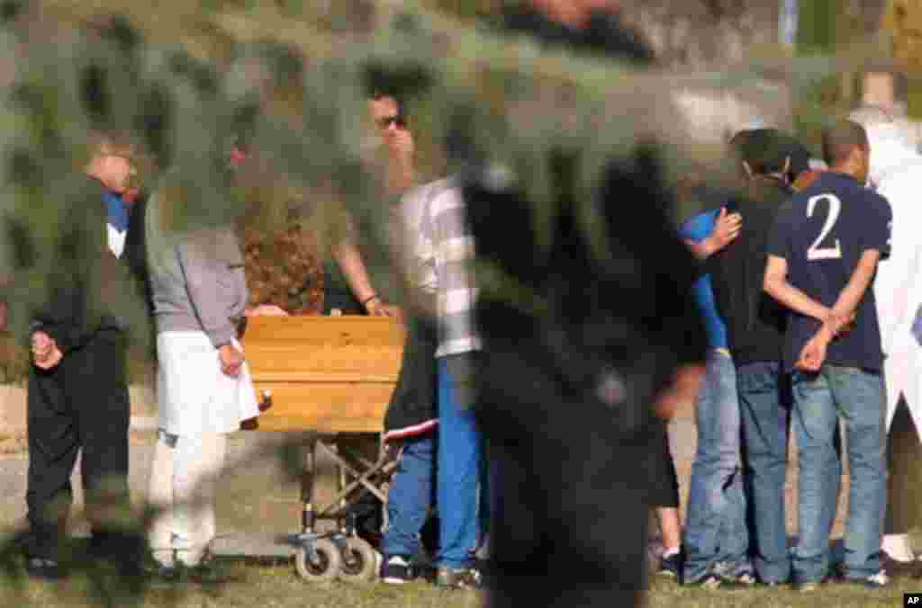 Relatives react by the coffin of Mohamed Merah during his funeral ceremony near Toulouse, southern France, Thursday, March 29, 2012. Mohamed Merah is blamed for a series of deadly shootings which have shocked France and upended the country's presidential