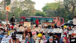 معترضان با پلاکاردهایی که روی آن نوشته «ما کودتای نظامیان را نمی‌پذیریم» در شهر یانگون تجمع کرده‌اند. 